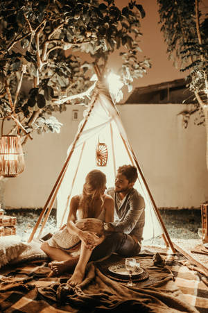 Couple Siting Inside A Tent Wallpaper