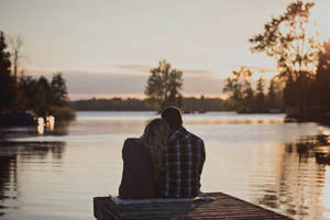 Couple Sitting On Deck Wallpaper