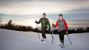 Couple Snowshoeing Walking Sunset Wallpaper