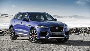 Cruise The Open Road In A Stylish Blue Jaguar Car Wallpaper
