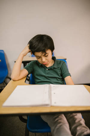 Crying Sad Boy On Desk Wallpaper