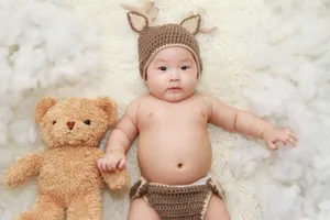 Cute Baby With Knitted Hat And Stuffed Bear Wallpaper