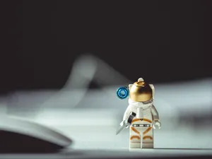 Cute Toy Astronaut In Space Wallpaper