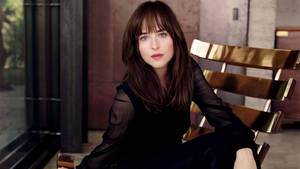 Dakota Johnson Sitting Elegantly Wallpaper