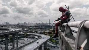 Deadpool - A Man Sitting On A Railing Wallpaper
