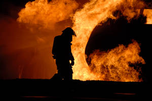 Dejected Fireman In The Middle Of A Fire Wallpaper