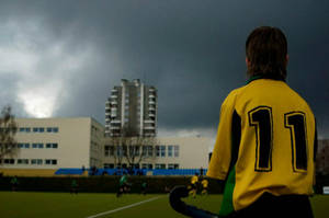 Determined Athletes Playing Field Hockey Under The Grey Sky. Wallpaper