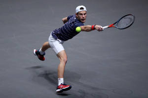 Diego Schwartzman Delivering A Powerful Leap Shot In A Tennis Match. Wallpaper