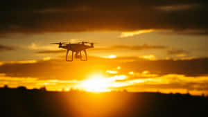 Drone Silhouette Against Sunset Sky Wallpaper