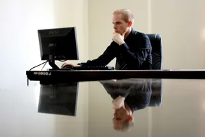 Dynamic Entrepreneur Crafting Success In His Office Wallpaper