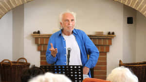 Elderly Man Speakingat Podium Wallpaper