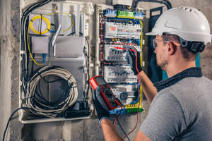 Electrical Technician Testing Fuse Box Voltage Wallpaper