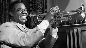 Elevating Jazz Music - Louis Armstrong Laughs While Playing His Trumpet Wallpaper