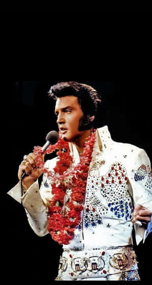 Elvis Presley In A White Dress Singing Into A Microphone Wallpaper