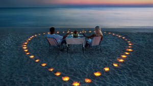 Enamoured Couple Enjoying A Idyllic Beach Getaway Wallpaper