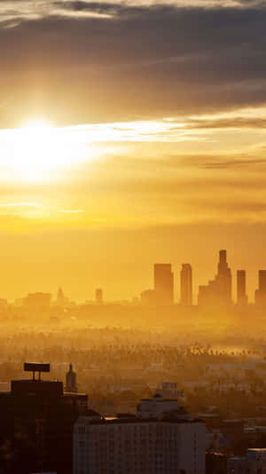 Enjoying A Scenic View Of Downtown Los Angeles While Using An Iphone Wallpaper