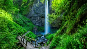 Enjoying A Stunning View Of A Tranquil Waterfall And Bridge Wallpaper