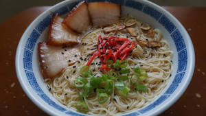 Enjoying Delicious Hakata Ramen With Thin Noodles Wallpaper