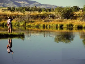 Enjoying The Peaceful View Of Fly Fishing In The Mountains Wallpaper