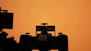 Exciting Action Of F1 Racing Car In Silhouette Wallpaper