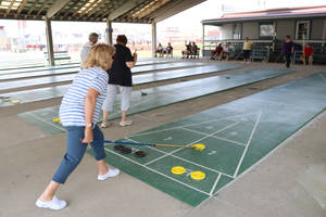 Female Playing Shuffleboard On Court Wallpaper