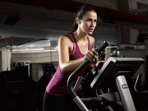 Fit Woman Running On Treadmill Wallpaper