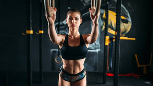 Fit Woman Using Gymnastic Rings Wallpaper