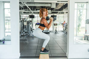 Fitness Women Lifting Dumbbells Wallpaper