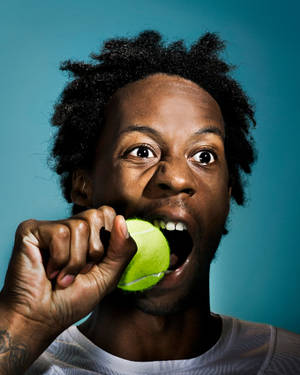 Gael Monfils Biting A Tennis Ball Wallpaper