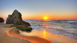 Giant Rock Formation On Beach Sunset Wallpaper