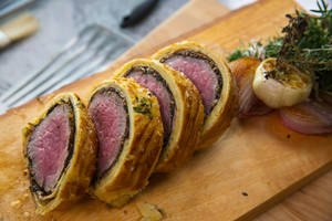 Gourmet Beef Wellington Garnished With Garlic And Rosemary Wallpaper