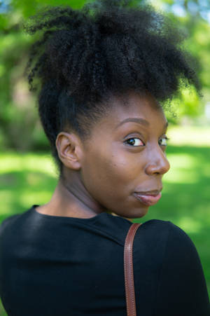 Graceful Black Girl Looking Back With A Captivating Gaze. Wallpaper