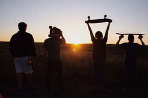 Group Of Friends Silhouette Holding Skateboards Wallpaper