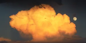Half-lit Moon Rising Above Dark Clouds Wallpaper