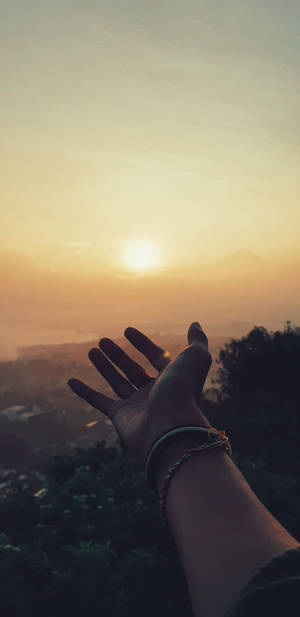 Hand Reaching For Sunset Portrait Wallpaper