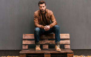 Handsome Man Sitting On Bench Wallpaper