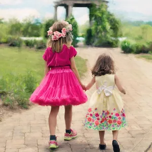 Happy Cute Sisters Holding Hands While Walking Wallpaper
