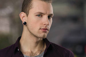 Headshot Of A Man With An Earring Wallpaper