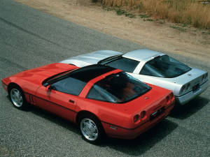 High-speed Elegance: Two C4 Corvettes Racing On Open Roads Wallpaper