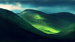 Hillside Under The Dark Clouds Wallpaper