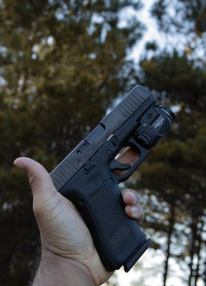 Holding A Glock With Flashlight Wallpaper