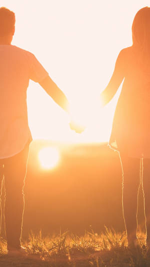 Holding Hands Couple Facing Sunset Back Angle Shot Wallpaper