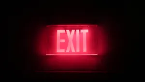 Illuminated Exit Sign Displayed On Black Tablet Screen Wallpaper