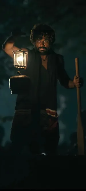 Intense Look Of Allu Arjun As Pushpa Raj Under A Lamp Light Wallpaper