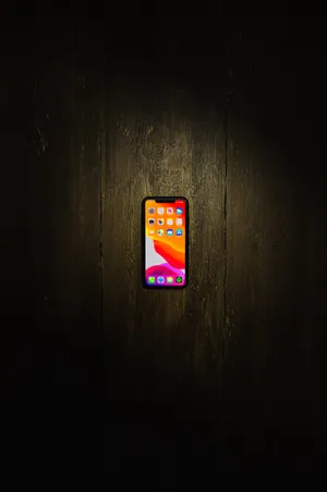 Iphone Xs Max On Wooden Floor Wallpaper