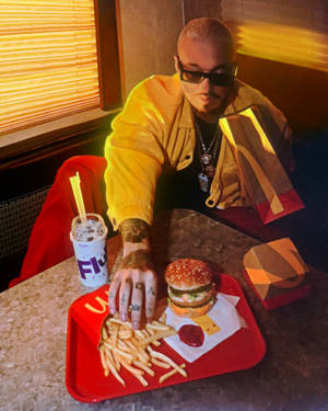 J Balvin Eating Burger And Fries Wallpaper