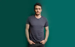 James Franco In Grey Shirt Against A Vibrant Green Background Wallpaper