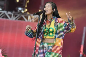 Jhené Aiko Striking A Pose In A Blue Outfit Wallpaper