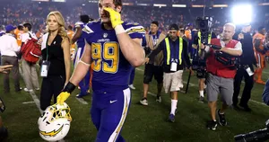 Joey Bosa Fiercely Fighting On The Football Field Wallpaper