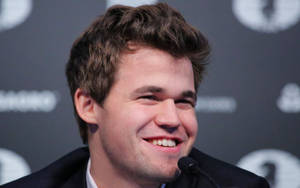 Joyful Magnus Carlsen Celebrating His Winning Move Wallpaper